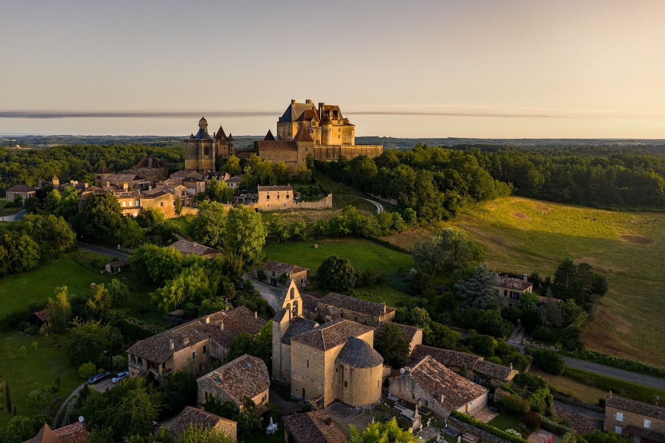 Le château de Biron et son village dans la lumière du soir
