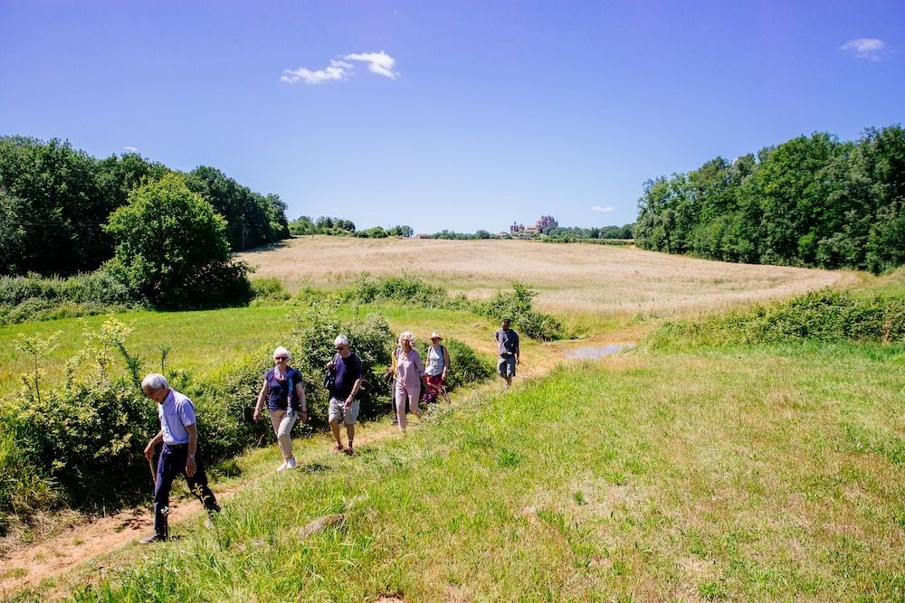 Randonneurs dans la campagne au pied du château de Biron