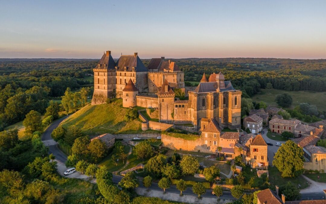 Le château de Biron vu du ciel dans la lumière dorée de fin de journée