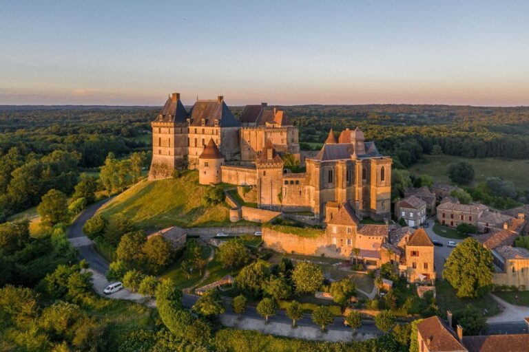 Le château de Biron vu du ciel dans la lumière dorée de fin de journée