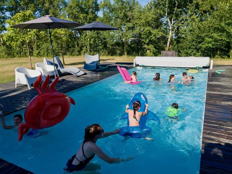Children swimming in the heated pool at Maison Les Terrasses, Dévillac