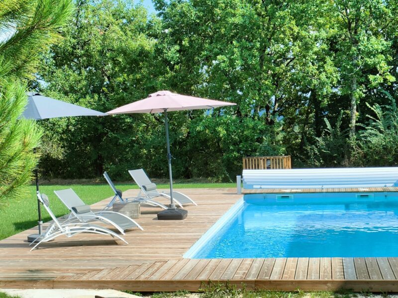 Terrasse et piscine chauffée entourées de verdure