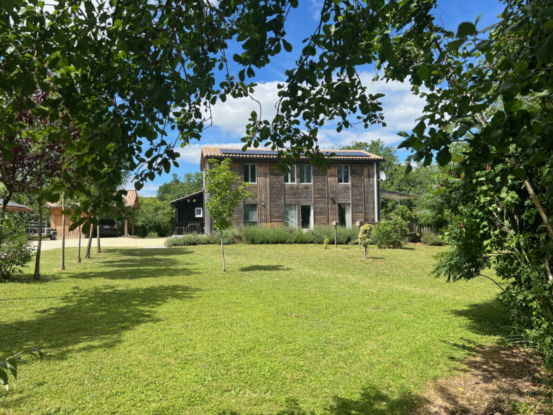 La maison en bois vue depuis la pelouse du jardin